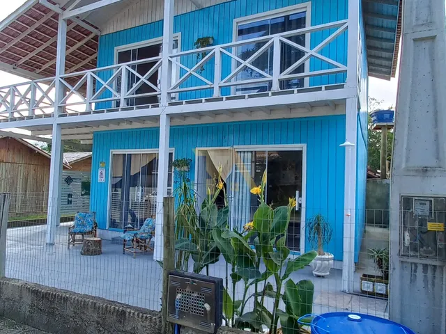 Imagem 2: Casa Charmosa em Estilo Praiano, com Fachada Colorida e Ampla Varanda Que Integra os Ambientes Internos Ao Ar Livre