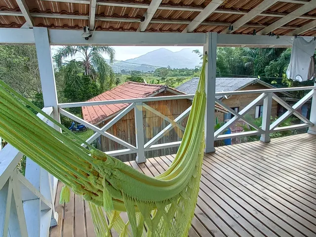 Imagem 9: Casa Charmosa em Estilo Praiano, com Fachada Colorida e Ampla Varanda Que Integra os Ambientes Internos Ao Ar Livre
